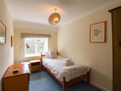 a bedroom with a bed with a stuffed animal on it at Orchard Barn in Salcombe