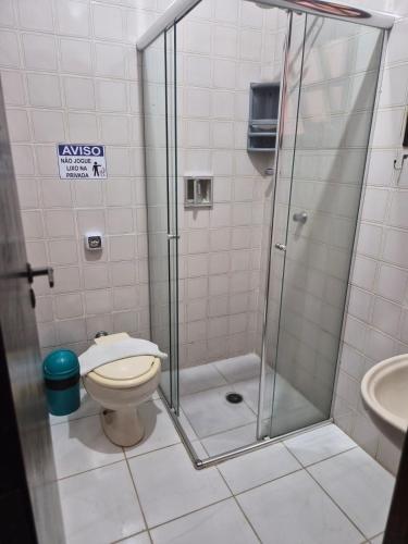 a bathroom with a shower with a toilet and a sink at Hotel Pousada Cavalo Marinho in Boicucanga