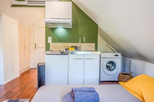 a kitchen with a sink and a washing machine at Les Cognassiers - Studio Cosy & Equipé - Parking Gratuit - Professionnels & Familles in Illkirch-Graffenstaden