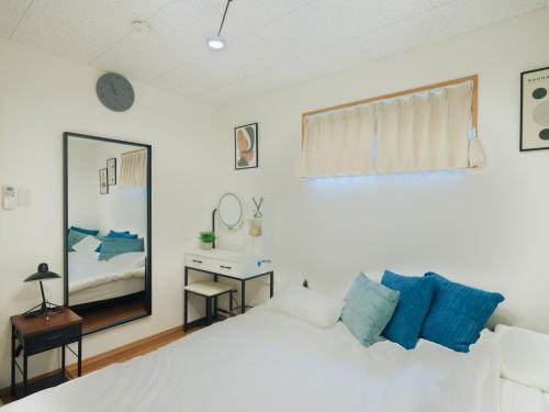 a bedroom with a white bed and a mirror at Aso Grand View in Aso