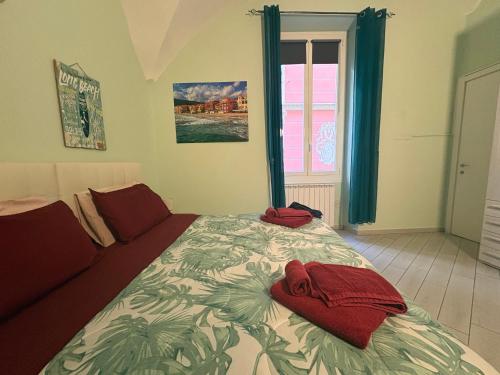 a bedroom with a bed with red towels on it at b&b La Rosa dei venti in Alassio