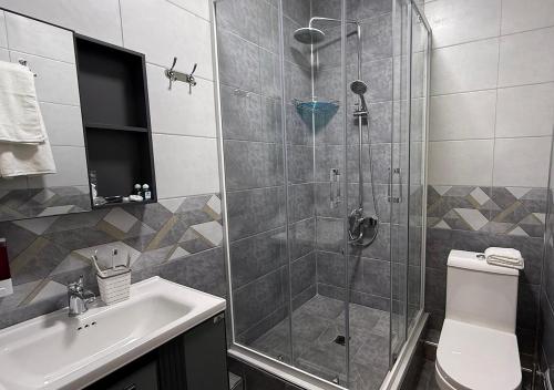 a bathroom with a shower with a toilet and a sink at Mumtoz East Hotel in Bukhara