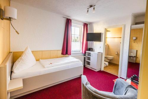 a hotel room with a bed and a bathroom at Pension Lachmöwe in Zinnowitz
