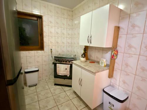 a small kitchen with white cabinets and an oven at Refugio Escondido in Isla de Maipo