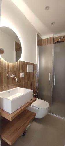 a bathroom with a sink and a toilet and a mirror at Nest Scilla in Scilla