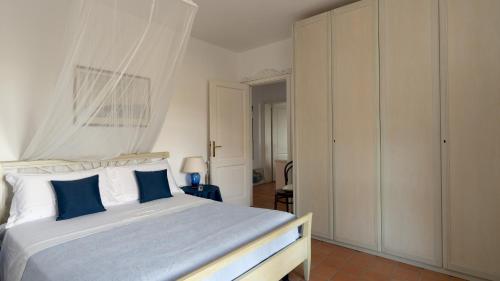 a bedroom with a large bed with blue pillows at VILLA PERELLE 8, Emma Villas in Rio nellʼElba