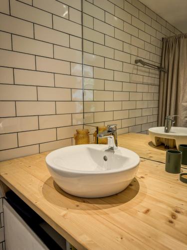 a bathroom with a white sink on a wooden counter at Maisonnette des vignes in Albertville