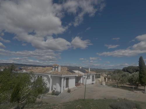 a large white house with a roof at FINCA EL OLIVAR Casa Rural in Los Corrales