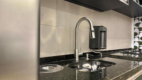 a kitchen counter with a sink in a kitchen at Studio Red 14 - Sorocaba in Sorocaba