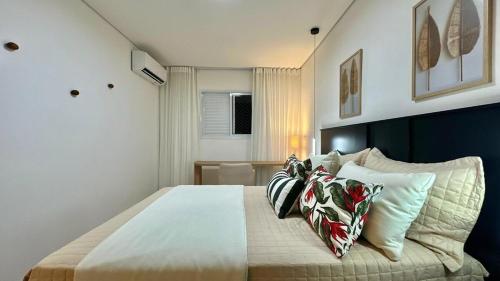 a bedroom with a large bed with pillows on it at Studio Red 14 - Sorocaba in Sorocaba