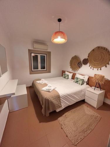 ein Schlafzimmer mit einem Bett und einer Pendelleuchte in der Unterkunft Herdade do Gamito in Crato