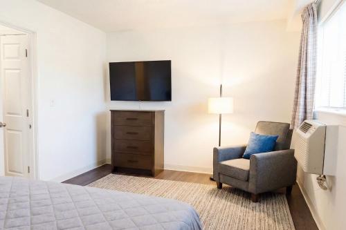 a bedroom with a bed and a chair and a television at InTown Suites Extended Stay Louisville KY - Preston Hwy in Louisville