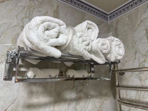 a bunch of towels on a towel rack in a bathroom at Ayvon Guesthouse in Samarkand