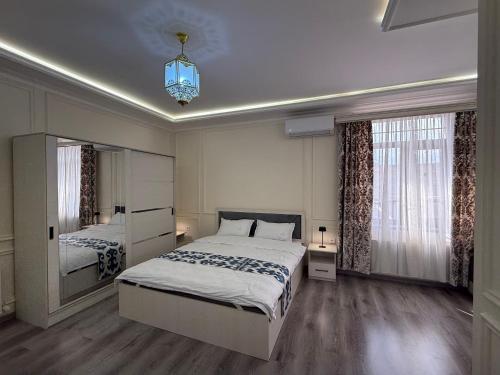 a bedroom with two beds and a large window at Ayvon Guesthouse in Samarkand