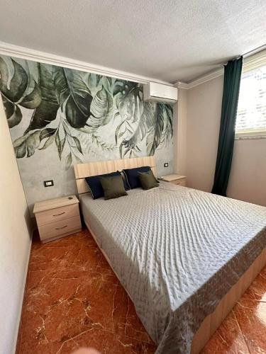 a bedroom with a bed with a painting on the wall at apartament gezuar in Golem
