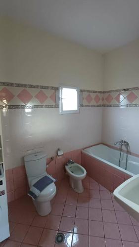 a bathroom with a toilet and a tub and a sink at Villa Albano in Delvinë