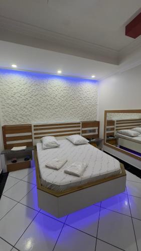 a bedroom with two beds and a blue light at Hotel Costa Leste in São Paulo