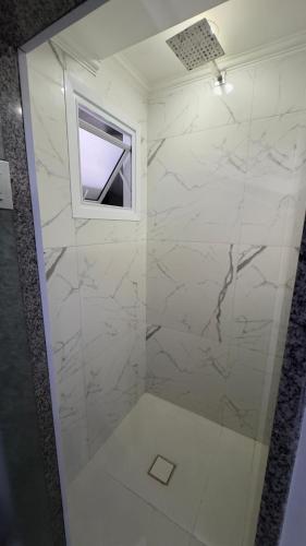 a bathroom with a glass shower with a window at Hotel Costa Leste in São Paulo