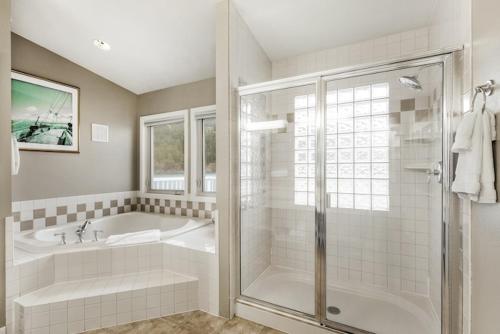 a bathroom with a shower and a tub and a sink at Rosario Resort in Eastsound