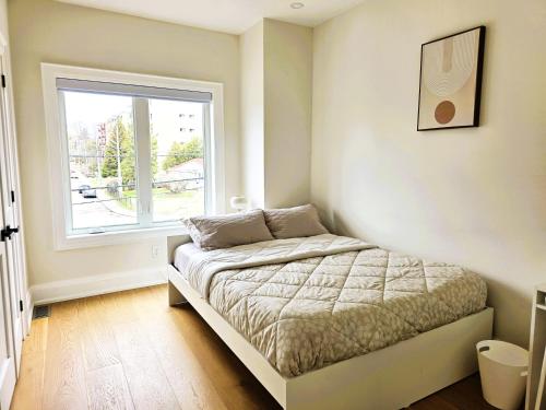 a small bedroom with a bed and a window at Luxury House with Open Living Space in Toronto