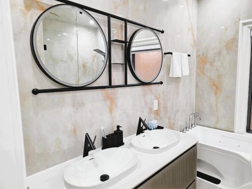 a bathroom with two sinks and a mirror at Luxury House with Open Living Space in Toronto
