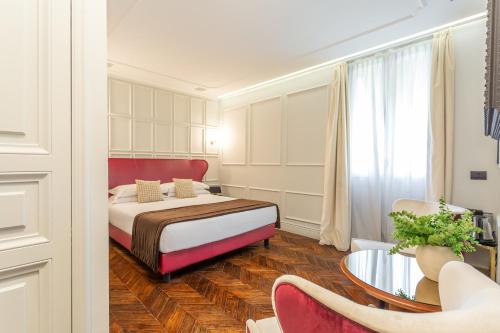 a bedroom with a bed and a table and chairs at Hotel The Corner Roma in Rome