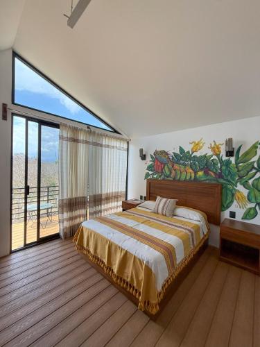 a bedroom with a bed with a painting on the wall at Cabañas Raíces del Cielo in Estorpio