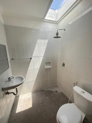 a bathroom with a toilet and a sink at Plawa Bali Guest House in Canggu