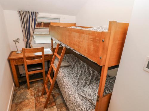 a bedroom with a bunk bed and a desk at Trelessy Lodge in Amroth