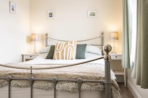 a bedroom with a metal bed with pillows on it at California Cottage in Barnard Castle