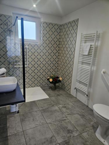 a bathroom with a sink and a toilet and a window at Logis Loire Hotel - Les Cocottes Restaurant in Les Rosiers