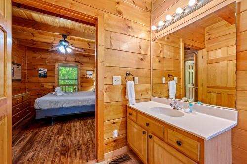 a bathroom with a bed and a sink and a mirror at Getaway Cabin Loft Oasis Mountain View in Gatlinburg