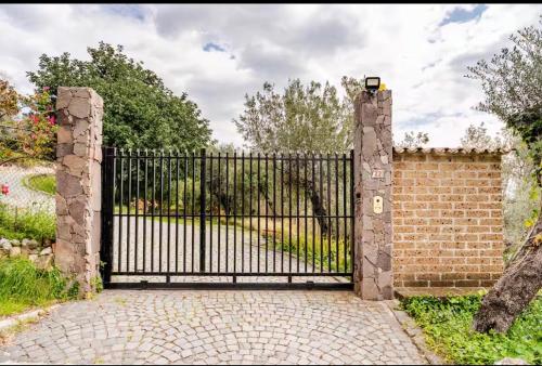 a black iron gate with a brick wall at Villa Afrodite in Mondragone