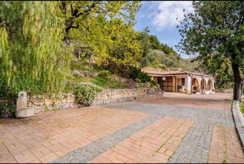 a house with a brick driveway and a stone wall at Villa Afrodite in Mondragone