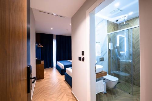 a bathroom with a shower and a toilet and a sink at Duka's Boutique Hotel in Ksamil