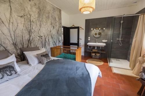 una camera da letto con un letto e un bagno con una doccia di Maison de mordoit a Pissos