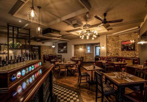 um restaurante com mesas e cadeiras e um bar em Victoria Inn em Londres
