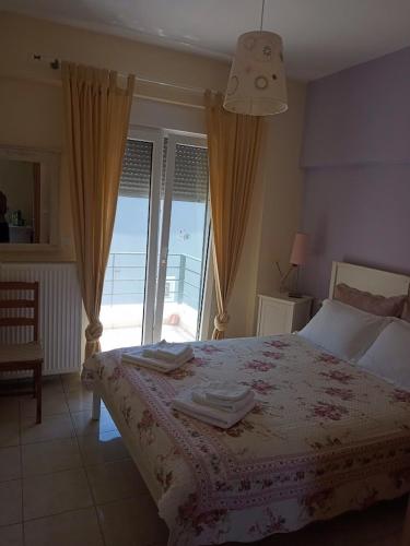 a bedroom with a bed with a view of the ocean at EFFIE'S VACATION by the sea in Kanali