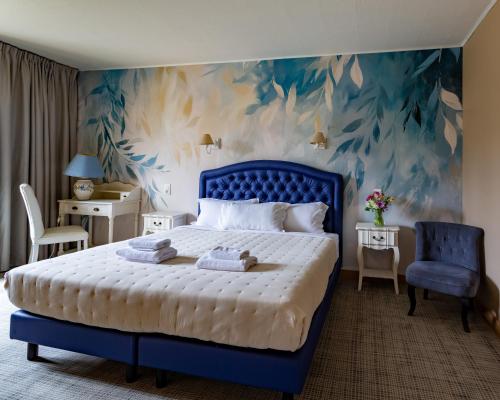 a bedroom with a blue bed and a blue wall at Le Cro-Magnon - hôtel - piscine - climatisation in Les Eyzies-de-Tayac