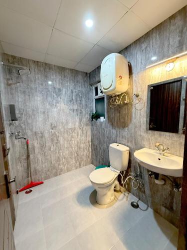 a bathroom with a toilet and a sink at Meera Kunj in Chhatikara