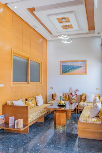 a living room with couches and a table at Hotel Golden Sunset Dakhla in Dakhla