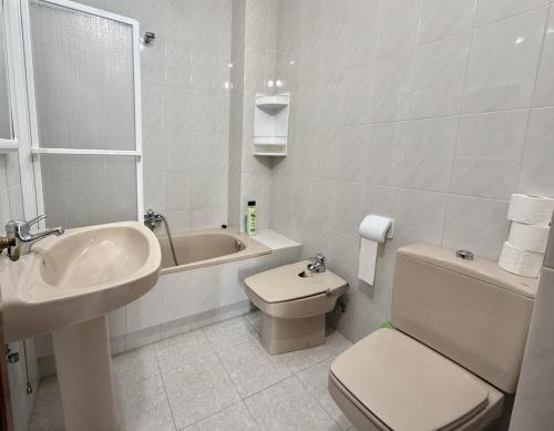 a bathroom with a sink and a toilet and a bath tub at Apartamento Salceda - 6901 in Noja