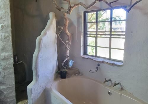 a white bath tub in a bathroom with a window at The Storybook Nook in Kaapsehoop