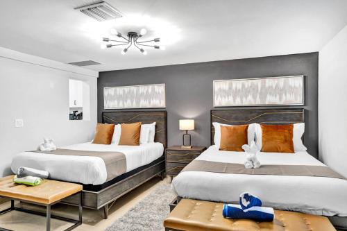 a bedroom with two beds and a table at Beachside Studio w Pool Access Steps from the Shore in Pompano Beach