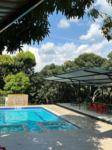 a swimming pool with an umbrella and tables and chairs at San Alejo in San Joaquín