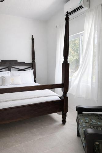 a bedroom with a wooden bed and a window at Rivers End Guesthouse in Hope Bay