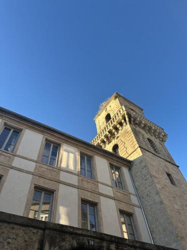 a building with a clock tower on top of it at Appartement calme et lumineux au cœur d'Arles in Arles