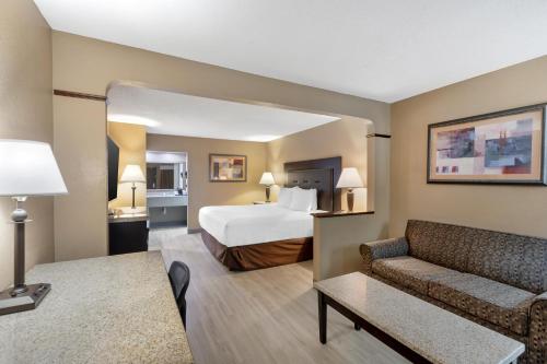 a hotel room with a bed and a couch at Best Western Lumberton in Lumberton