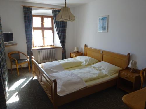 a bedroom with a bed in a room with a window at Schloß-Hotel Hirschau in Hirschau