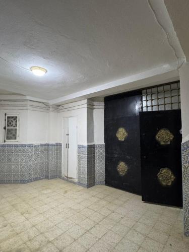 an empty room with black and gold tiled walls at Appartement T3 équipé à Biskra in Biskra